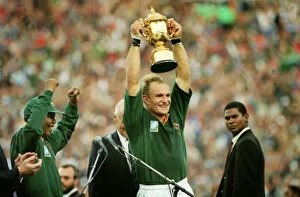 Rugby Collection: Francois Pienaar lifts the World Cup for South Africa as Nelson Mandela cheers