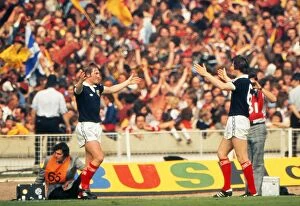 Images Dated 4th June 1977: Kenny Dalglish celebrates his goal with Bruce Rioch in front of the Scotland fans at Wembley
