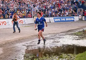 Kevin McAllister of Chelsea runs through the puddles with the Division Two trophy