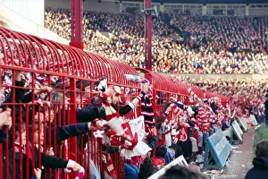 Manchester United fans hold their scarves through fences at the Stretford End in 1977