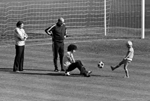 Background Prints: Paul Breitner sits on a ball with Helmut Schoen after West Germany training - 1974 World Cup