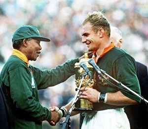Rugby Collection: South Africa captain Francois Pienaar receives the World Cup from Nelson Mandela in 1995
