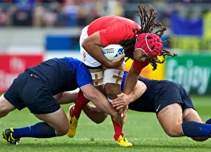 Tongas Paino Hehea is tackled by French defenders at the World Cup