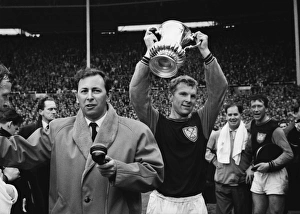 West Ham captain Bobby Moore lifts the FA Cup next to David Coleman in 1964